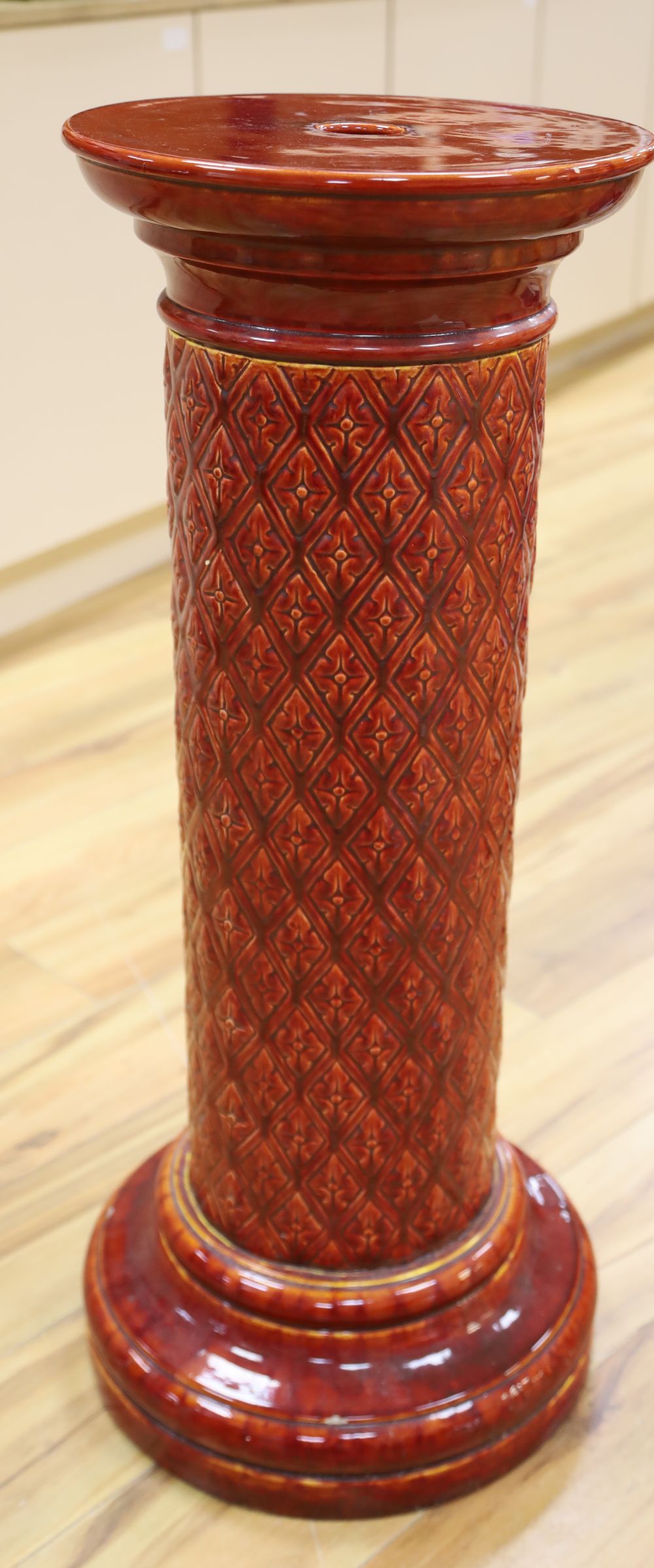 A Burmantofts plum glazed earthenware pedestal, 87cm high